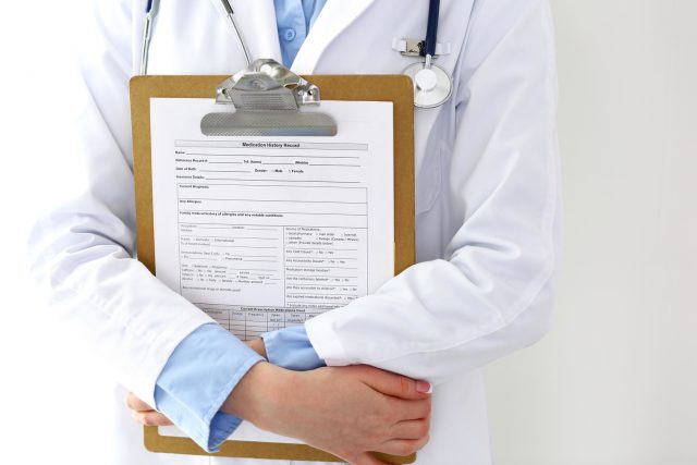 Female doctor filling up medical form on clipboard closeup.  Physician finishing up examining his patient in hospital and ready to give a prescription to help. Healthcare, insurance and medicine concept.