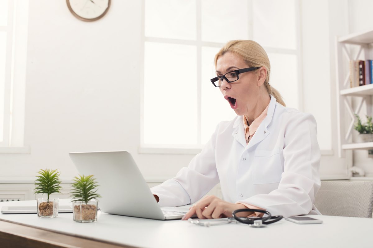 Shocked doctor looking at laptop