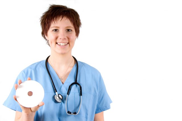 nurse in blue scrubs holding a DVD