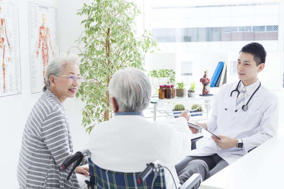 A young doctor and an elderly patient have a happy conversation