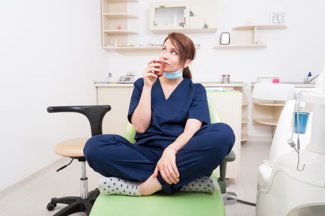 Woman dentist doctor thinking and having a coffee break